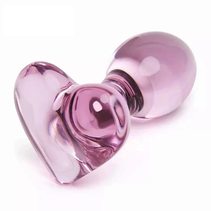 Smooth glass butt plug with pink heart base, beginner-friendly size, and polished crystal finish.