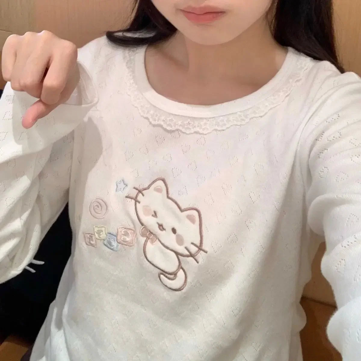 Pastel pink long sleeve tee with winking kitten embroidery, lace trim, and cozy fit for DDLG ABDL kawaii outfits