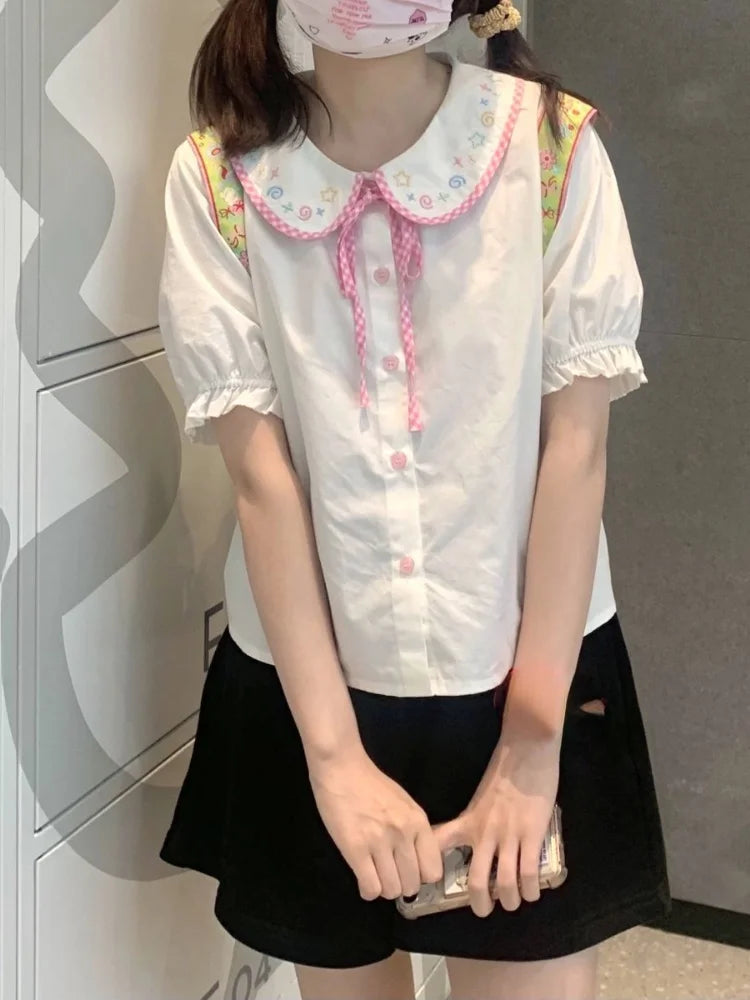 Kawaii preppy plaid blouse featuring doll collar and detailed mini cartoon embroidery for a polished look