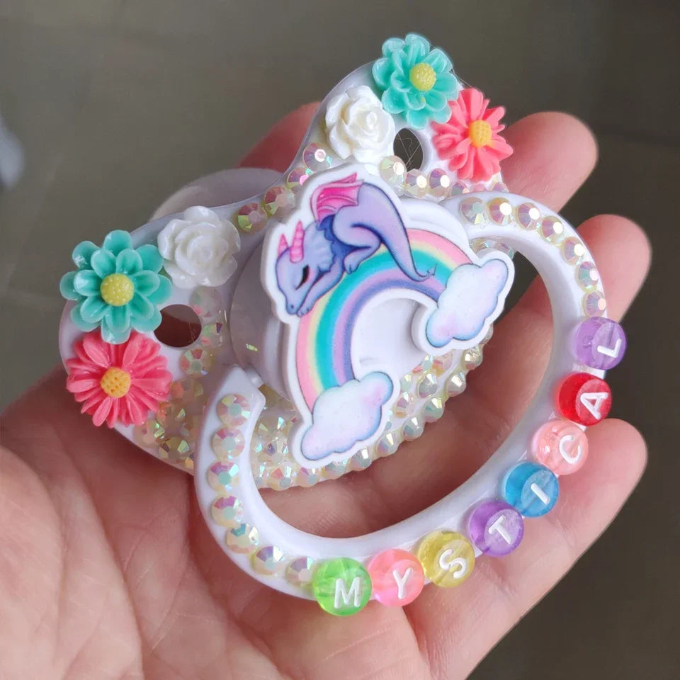 Pastel dragon pacifier with mystical rainbow letters, perfect for soft babycore aesthetics