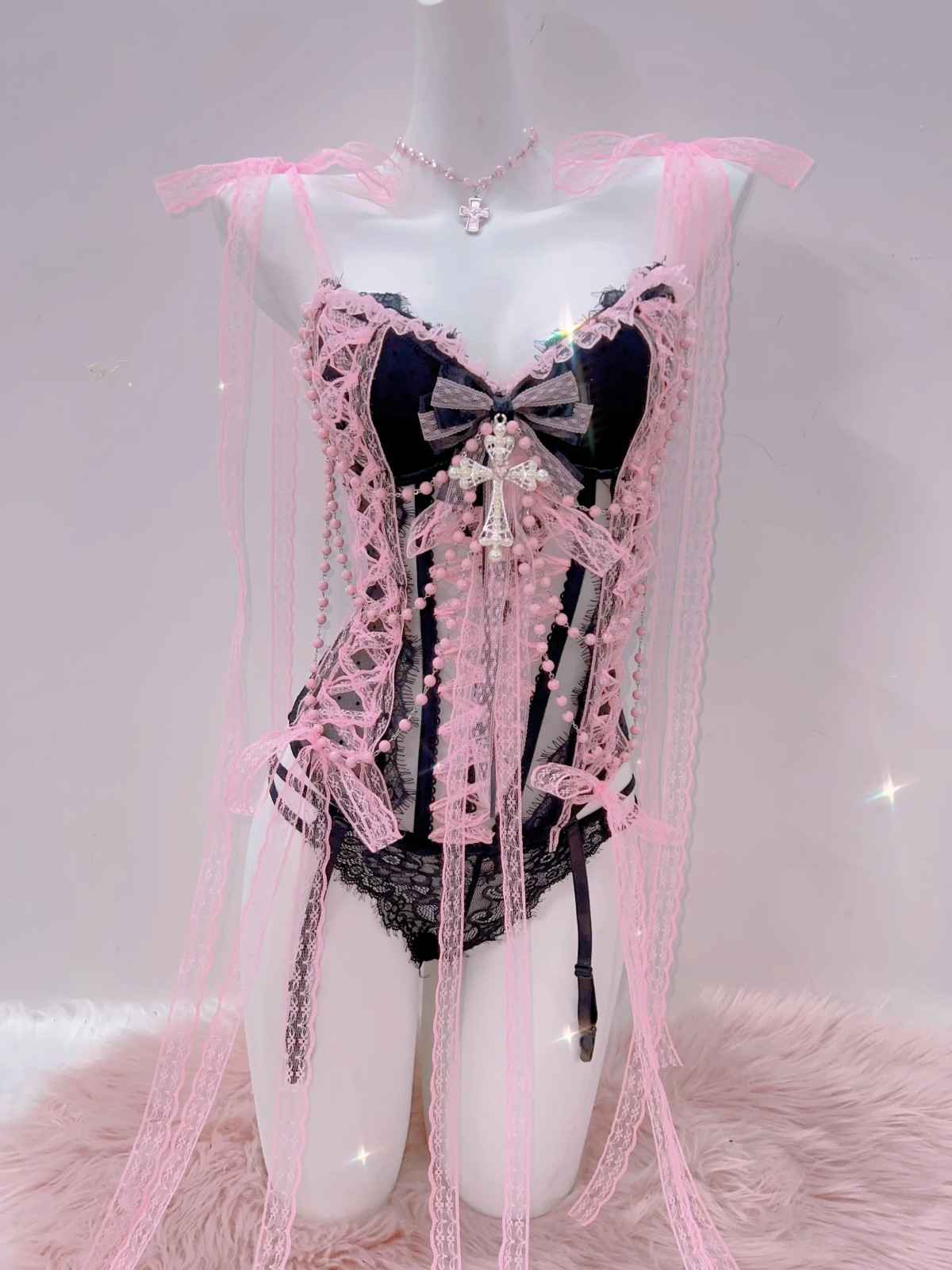 Soft pink boudoir lingerie with lace, bows, and striped sheer panels for a glamorous look.