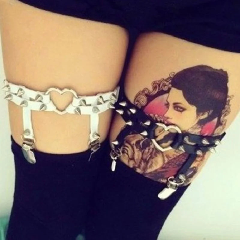White and black Spiked Rebel Heart Garters worn on both legs for edgy style