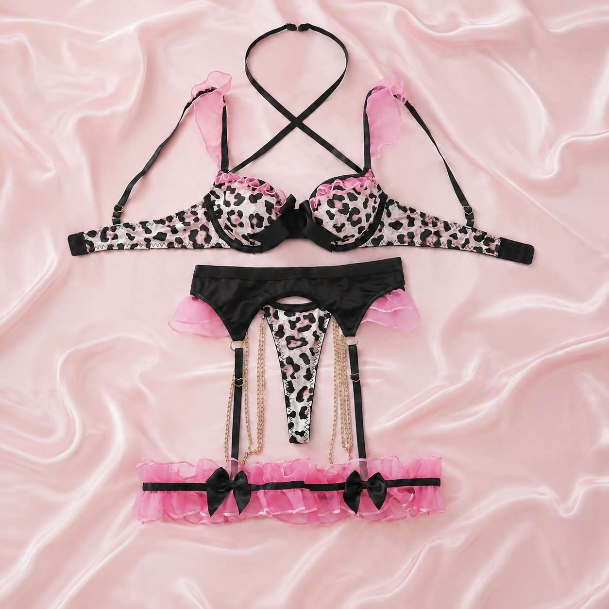 Flat lay of coquette leopard bow ruffle lingerie set with garter belt and thigh bands