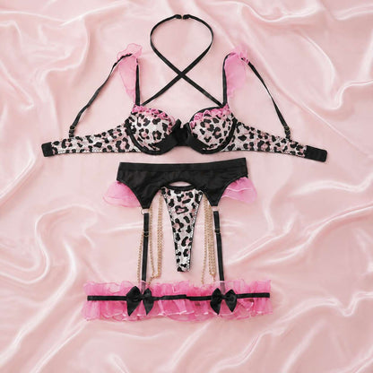 Flat lay of coquette leopard bow ruffle lingerie set with garter belt and thigh bands