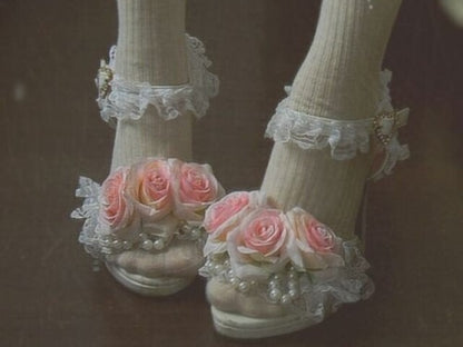 White heels decorated with pink roses, frills, and pearl accents — romantic princesscore shoes for dreamy outfits or special occasions.