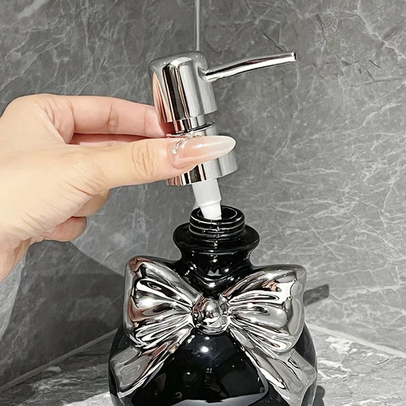 Cute black and silver bow-shaped soap dispenser, playful cutecore bathroom decor with classy twist