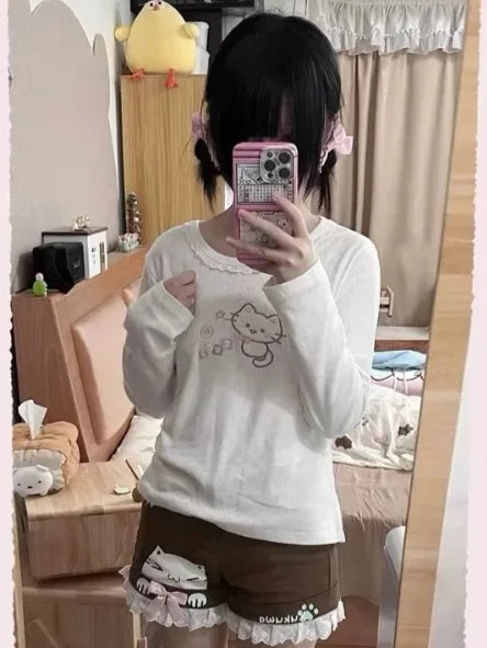 Peach long sleeve tee with embroidered winking kitten, lace accents, and relaxed fit for kawaii DDLG ABDL looks