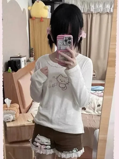 Peach long sleeve tee with embroidered winking kitten, lace accents, and relaxed fit for kawaii DDLG ABDL looks