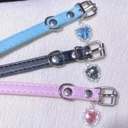 Set of three vegan leather chokers in blue, black, and pink with heart pendants and adjustable straps