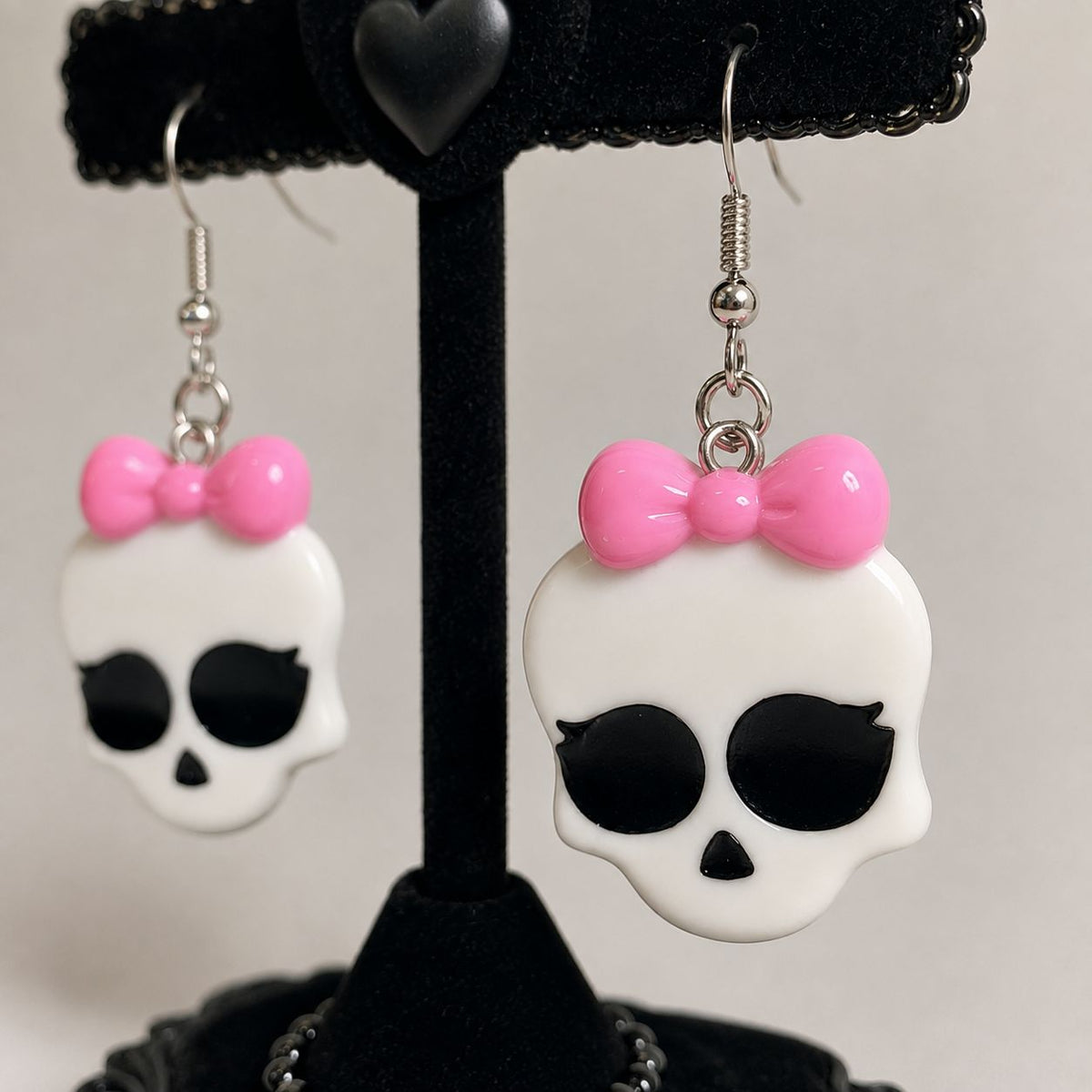 Bright pink bow detail on kawaii monster babygirl skull earrings