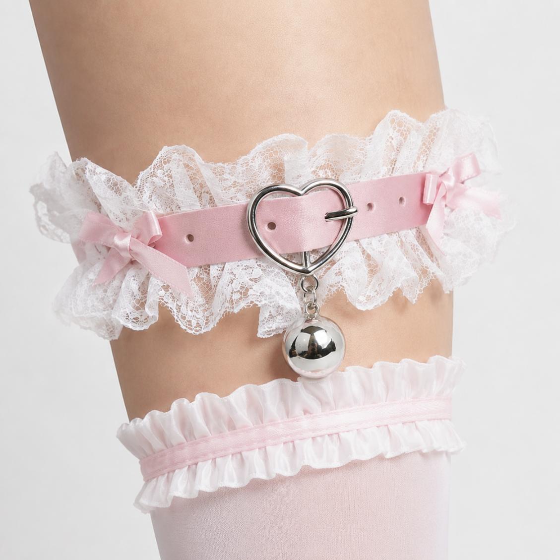 Close up of heart shaped centerpiece and ruffled lace on pastel pink coquette garter