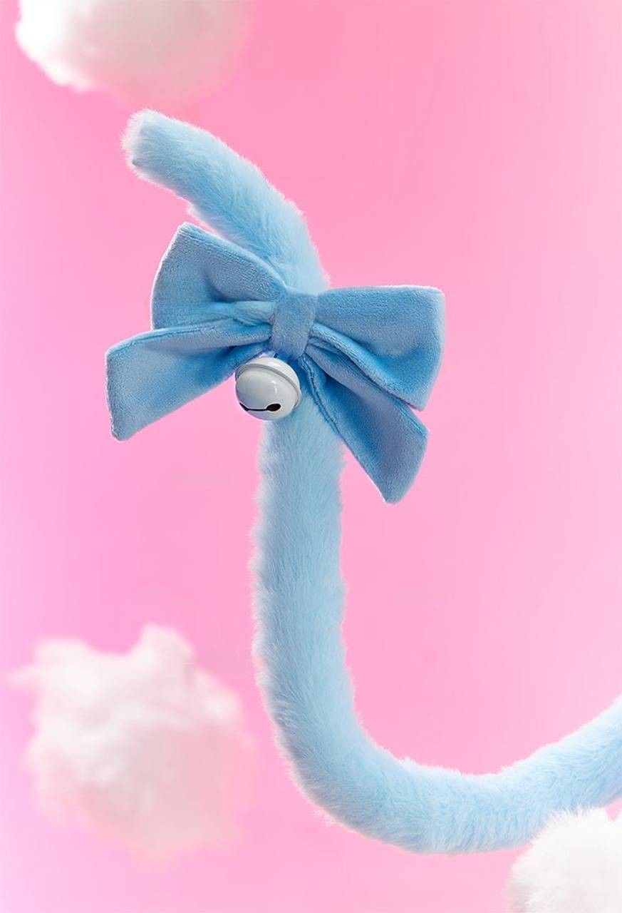 Close-up detail of pastel blue kitty cosplay tail with ribbon and bell attachment from kawaii kitty plush corset cosplay set, cutecore fantasy lingerie accessory