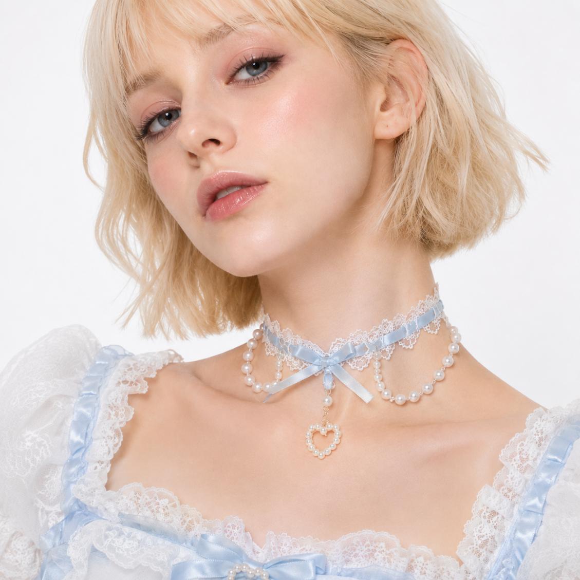 Close up of three graduated pearl strands draping beneath the bow on blue coquette choker