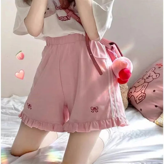 Pink track shorts with ribbon embroidery, white side stripes, and ruffle trim for kawaii DDLG ABDL outfits