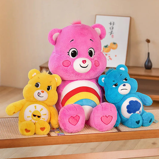 Rainbow Friends plush bears in pink, yellow, and blue with cozy pastel vibes