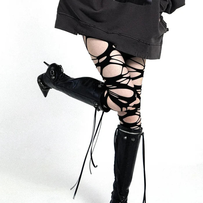 Ripped web tights styled as over knee stockings for grunge alternative looks