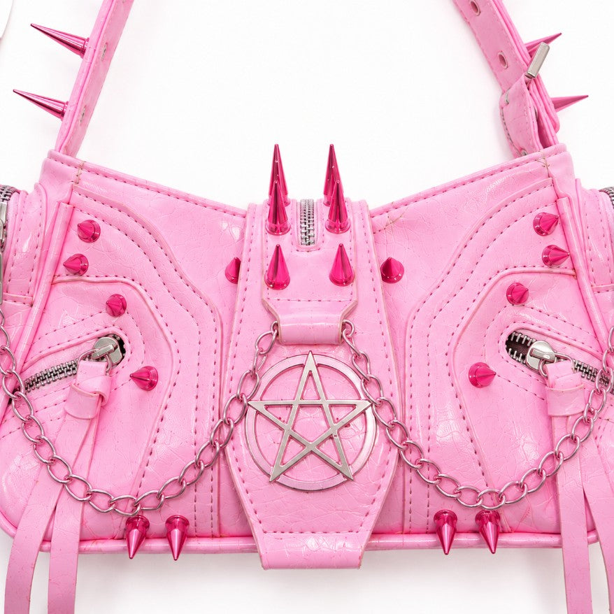 Close up of pentagram emblem and draped silver chains on pink kawaii gothic shoulder bag