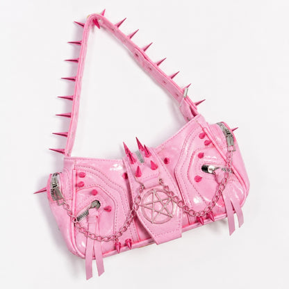 Flatlay of pink kawaii punk shoulder bag styled with gothic and DDLG accessories