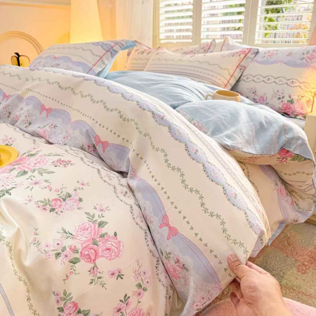 White and blue Victorian bedding with pink bow embellishments, combining classic elegance and soft kawaii charm